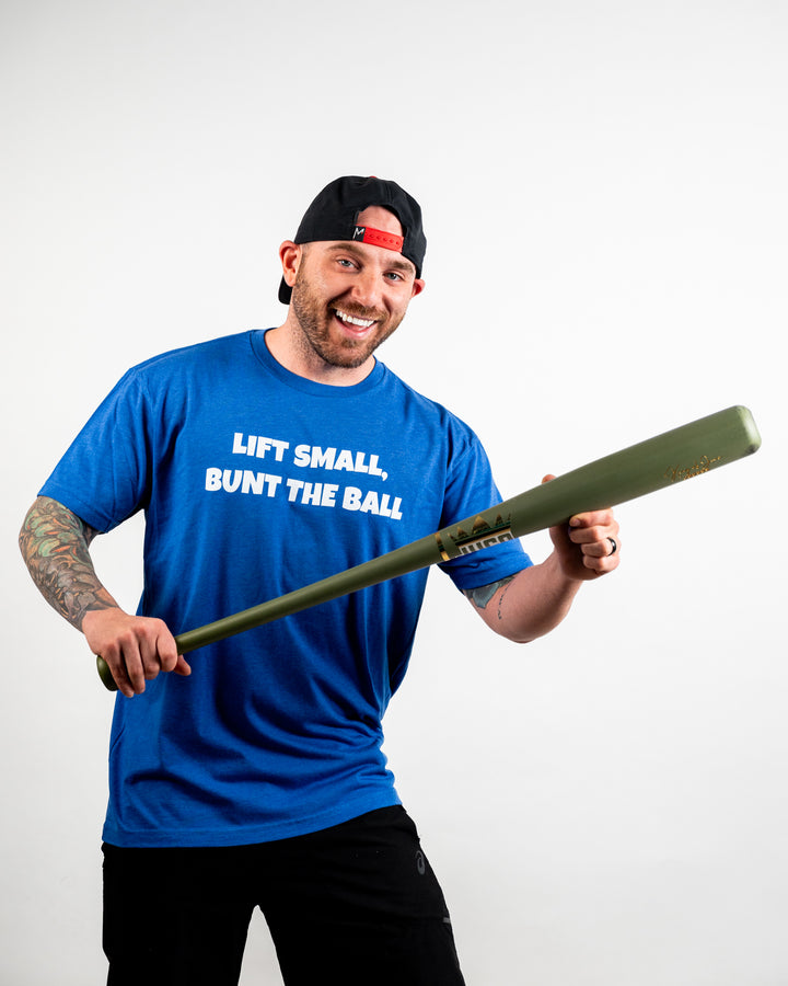 Cole wearing Momentum apparel Lift Small Bunt The Ball Blue Tee
