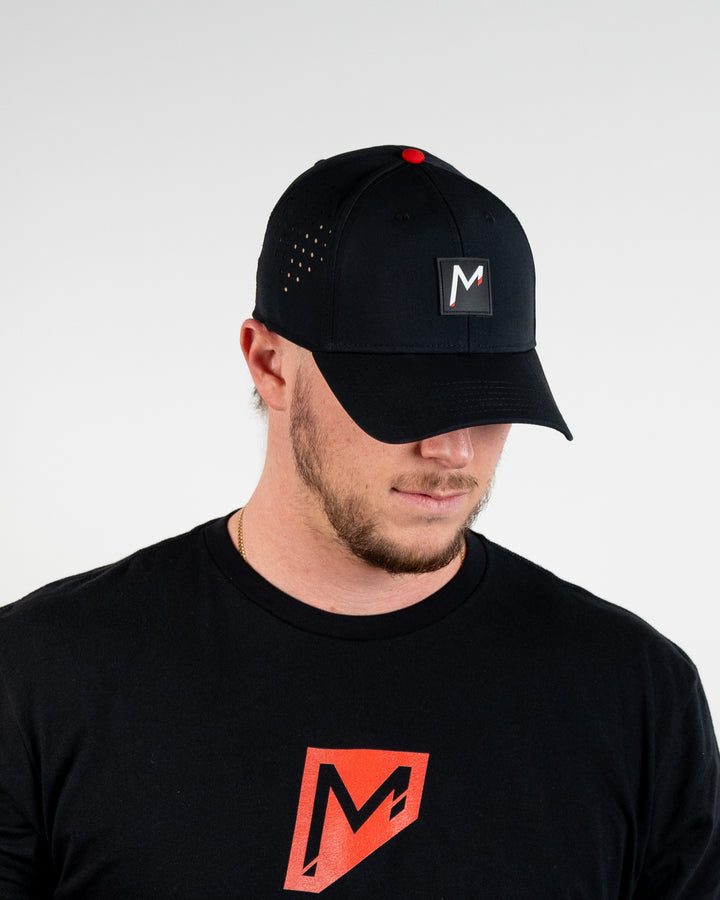 Tosh wearing Momentum apparel black performance hat snapback